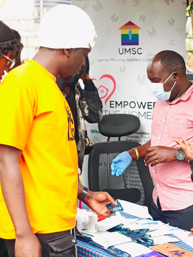 Handing out safe sex resources (PrEP & condoms) at a Uganda Minority Shelters Consortium booth.